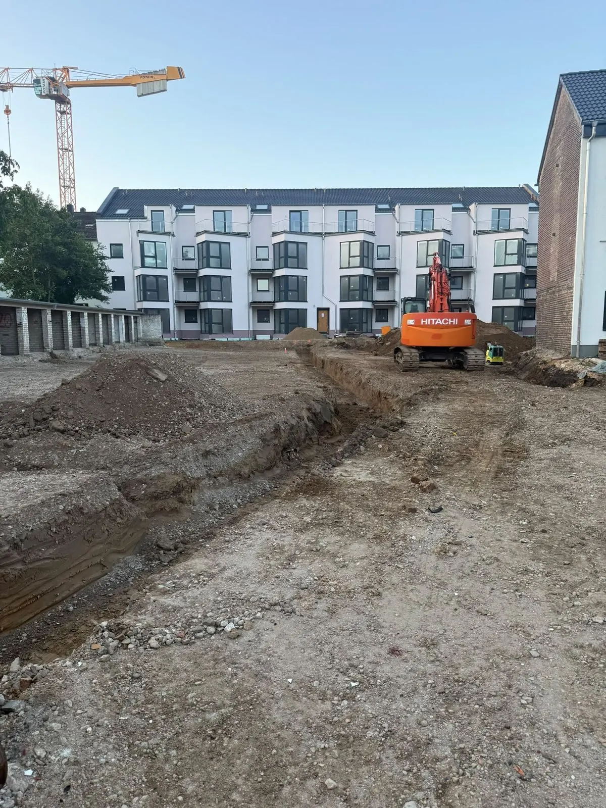 Bagger und Tiefbauarbeiten an einer Neubausiedlung
